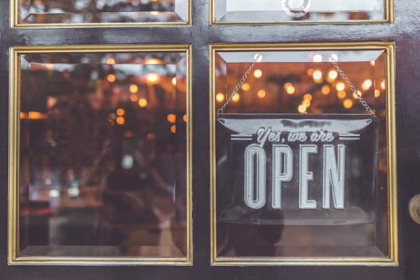 store front with open sign hanging in a window